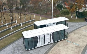 Two white capsule homes installed in a city park